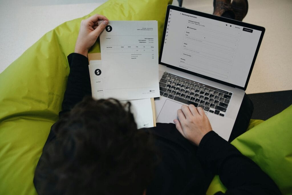 A person sitting on a bean bag chair working on a laptop. By SumUP on Unsplash
